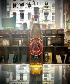 Produktbild Rooster Rojo Añejo Tequila Alt Attribut Rooster Rojo Añejo Tequila kaufen bei Belle Booze Tequila Glas mit goldener Farbe Alt Attribut Rooster Rojo Añejo gereifte Agave im Glas Flasche vor Agavenfeld Kulisse Alt Attribut Rooster Rojo Añejo Tequila aus Jalisco Mexiko