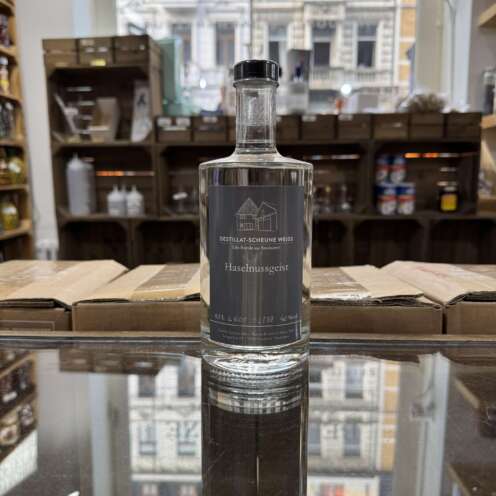 Produktbild Destillatscheune Haselnuss Geist Alt-Attribut: Destillatscheune Haselnuss Geist kaufen bei Belle Booze Haselnuss Geist im kleinen Tasting-Glas Alt-Attribut: Haselnuss Geist Destillatscheune – nussiger Genuss pur Flasche Haselnuss Geist mit Haselnüssen im Hintergrund Alt-Attribut: Destillatscheune Haselnuss Geist – intensives Nussdestillat aus Deutschland